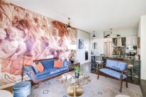 a living room with a large painting on the wall at Luxe Long Beach Condo with Pool 1 Mi to Shoreline! in Long Beach