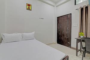 een slaapkamer met een bed, een bureau en een deur bij SSK Hotel in Lucknow