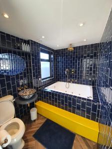 a bathroom with a tub and a toilet at Jacuzzi Suite in London