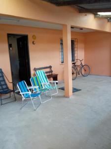 two chairs and a bench on a patio at Solar Dona Irma in Guaratuba