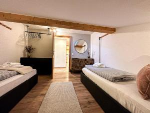 Habitación con 2 camas y espejo. en Bergliebe, en Oberstaufen