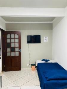 a bedroom with a bed with a blue blanket at HOSTEL ANPRADO in Guarulhos