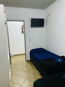 a bedroom with a bed and a flat screen tv at HOSTEL ANPRADO in Guarulhos