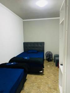 a bedroom with a bed with blue sheets on it at HOSTEL ANPRADO in Guarulhos