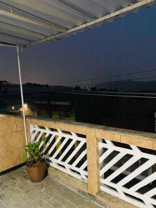 une clôture blanche sur un balcon avec une plante dans l'établissement HOSTEL ANPRADO, à Guarulhos