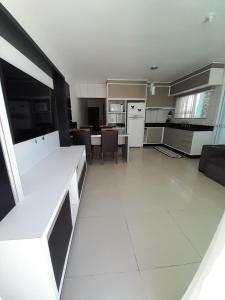 uma grande cozinha e sala de estar com electrodomésticos brancos em Casa a 200 mts da praia - prox Aeroporto NVG - CASA DA MEIA PRAIA em Navegantes