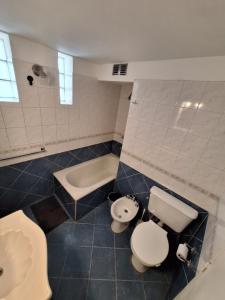 a bathroom with a toilet and a sink and a tub at CASA WRT in Villa Carlos Paz +5 photos