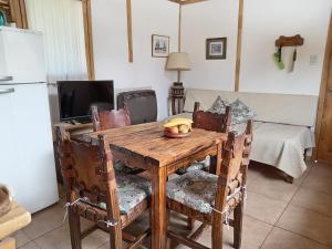 a wooden table with a bowl of fruit on it at Cabaña Paseo del Sol in San Martín de los Andes +23 photos