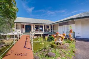 uma casa com um lago em frente em Honomu Home with Screened Lanai and Ocean Views! em Pepeekeo