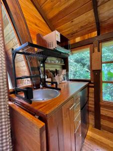 una cocina con fregadero en una casa pequeña en Sacha Urco Lodge y Bosque Protector, en Mindo