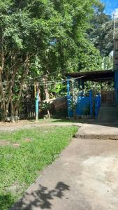 a park with a blue building and a tree at Casa e camping Reinaldo e Julia recanto das árvores in Itamonte