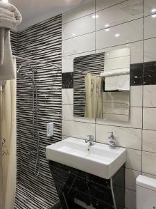 uma casa de banho com um lavatório, um espelho e um chuveiro em Damias rental rooms em Tessalónica