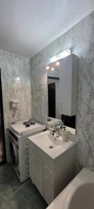a bathroom with a sink and a washing machine at Studio BDN in Sîngeorgiu de Mureş