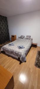 a large bed in a room with a wooden floor at Studio BDN in Sîngeorgiu de Mureş +6 photos