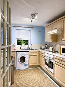a kitchen with a washing machine and a window at 1-Bed Apt Sleeps 2 20 min walk to Centre in Rochester