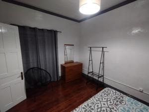 a bedroom with a bed and a dresser and two tripod at Casa das Palmeiras in Lajes das Flores