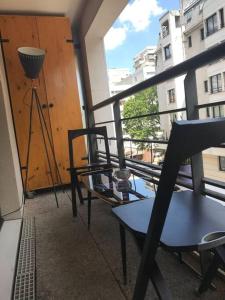 a balcony with a table and a chair on a balcony at Charmant studio grand balcon parking in Paris