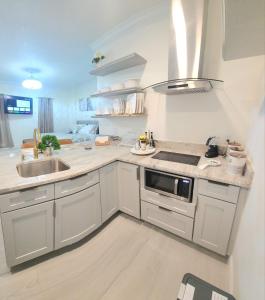 a white kitchen with a sink and a stove at Studio furnished in Kissimmee