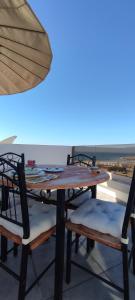 a wooden table with two chairs and an umbrella at surf house Agadir in Tama ou Ennza