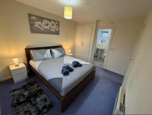 a bedroom with a bed with two blue towels on it at Modern Penthouse in Wellingborough