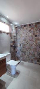 uma casa de banho com um WC e uma parede de azulejos em Tayyurt spots em Tama ou Ennza