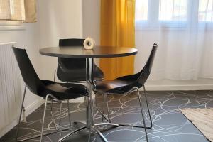 een tafel met stoelen en een vaas erop bij Tulsa Home - Cosy et calme in Saint-Quentin