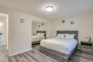 een witte slaapkamer met een bed en een spiegel bij Modern Puyallup Townhome with Backyard and Fireplace in Puyallup