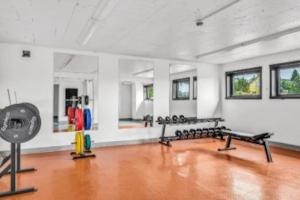 een fitnessruimte met een rij banken in een kamer bij Trivelig studioleilighet på byåsen med treningsrom, uteareal og parkering in Trondheim