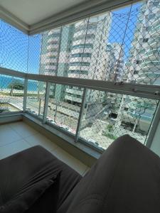 a window with a view of a large building at ITAPARICA BEACH CLUB in Vila Velha
