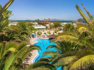 - une vue aérienne sur un complexe avec une piscine et des palmiers dans l'établissement Alua Suites Fuerteventura - All Inclusive, à Corralejo