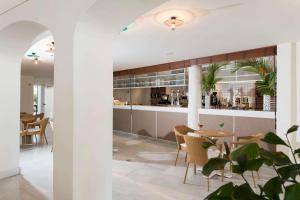 a kitchen and dining room with a table and chairs at Alua Suites Fuerteventura - All Inclusive in Corralejo