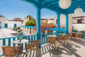 a patio with tables and chairs on a balcony at Alua Suites Fuerteventura - All Inclusive in Corralejo