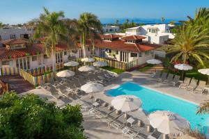 eine Luftansicht eines Resorts mit Pool und Sonnenschirmen in der Unterkunft Alua Suites Fuerteventura - All Inclusive in Corralejo