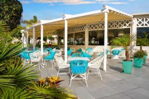 a group of chairs and tables on a patio at Alua Suites Fuerteventura - All Inclusive in Corralejo