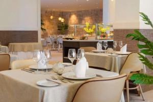 a dining room with tables and chairs with glasses at Alua Suites Fuerteventura - All Inclusive in Corralejo