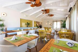 a restaurant with wooden tables and white chairs at Alua Suites Fuerteventura - All Inclusive in Corralejo
