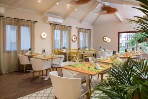 a dining room with wooden tables and white chairs at Alua Suites Fuerteventura - All Inclusive in Corralejo