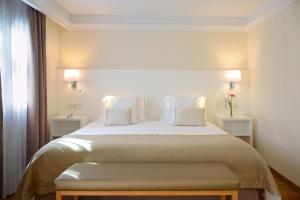 a bedroom with a large white bed with two night stands at Alua Suites Fuerteventura - All Inclusive in Corralejo