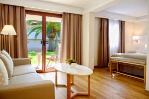a hotel room with a bed and a table at Alua Suites Fuerteventura - All Inclusive in Corralejo