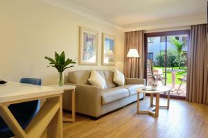 a living room with a couch and a table at Alua Suites Fuerteventura - All Inclusive in Corralejo