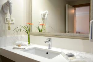 a bathroom with a sink and a mirror at Alua Suites Fuerteventura - All Inclusive in Corralejo