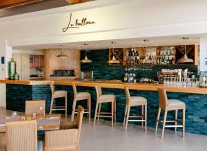 a bar in a restaurant with chairs and tables at AluaSun Mediterráneo in S'Algar