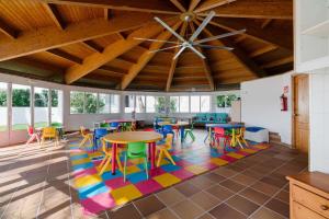 ein Zimmer mit Tischen und Stühlen auf einem farbenfrohen Teppich in der Unterkunft AluaSun Mediterráneo in S'Algar