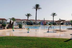 a swimming pool with water fountains in a resort at AluaSun Mediterráneo in S'Algar