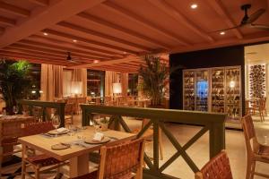 um restaurante com mesa, cadeiras e garrafas de vinho em Secrets Bahía Real Resort & Spa Adults only em Corralejo