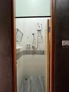 eine Dusche in einem Badezimmer mit Glastür in der Unterkunft Rotinis Hostel in Pom Prap + 20 Fotos