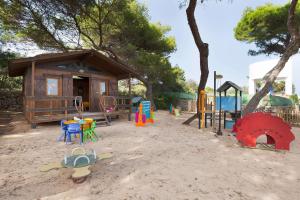 a playground with a small building and a play area at Alua Illa de Menorca in S'Algar