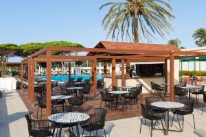 a patio with tables and chairs and a pavilion at Alua Illa de Menorca in S'Algar