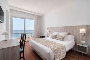 a bedroom with a large bed and a large window at AluaSun Doblemar in La Manga del Mar Menor