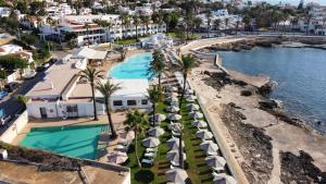 een luchtzicht op een resort met een zwembad en strand bij AluaSoul Menorca - Adults Only in S'Algar